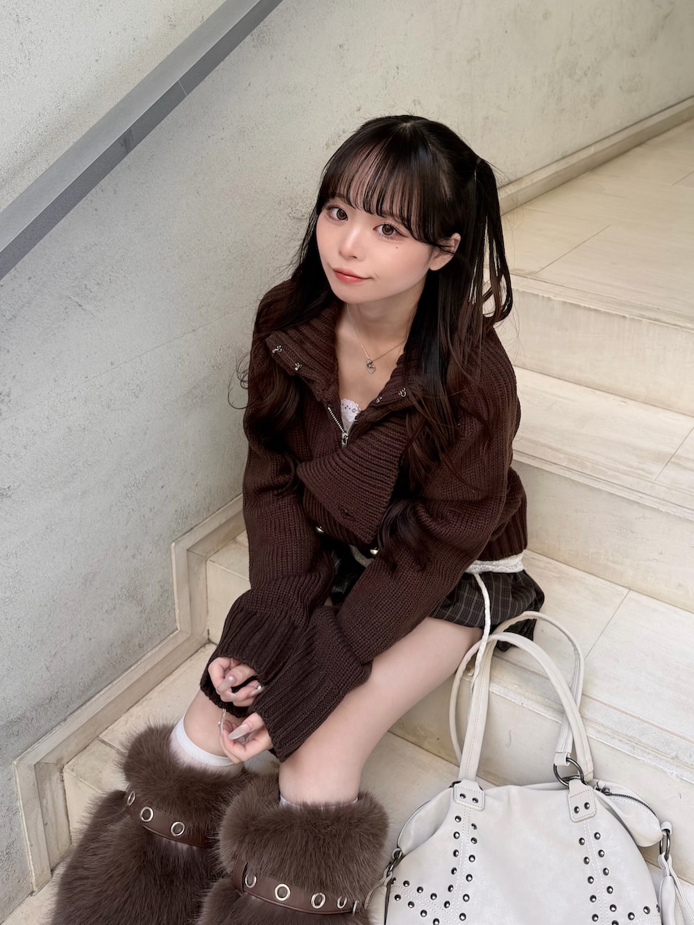 ブラウン系のニット/セーター、ホワイト系のキャミソール、ブラウン系のパンツを着用したレディースの秋コーディネートの3枚目の写真