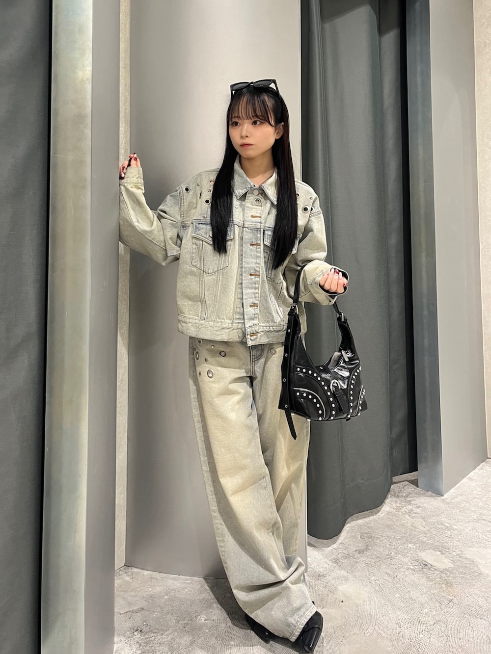 ブルー系のデニムジャケット、ブルー系のデニムパンツ、ブラック系のショルダーバッグを着用したレディースの冬コーディネートの2枚目の写真