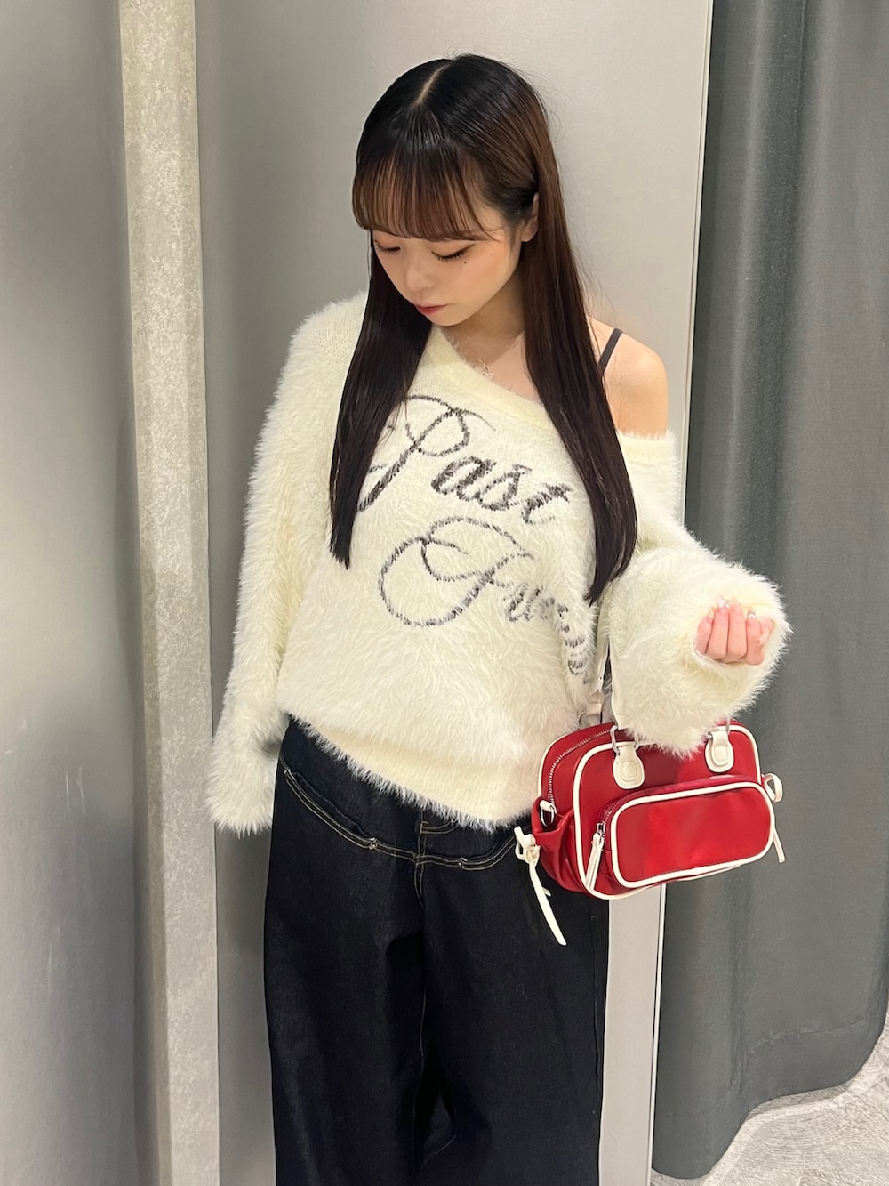 ホワイト系のニット/セーター、ブルー系のデニムパンツ、ホワイト系のパンプスを着用したレディースの秋コーディネートの4枚目の写真