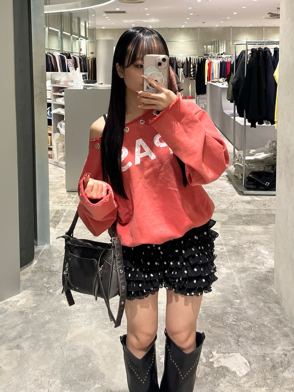 オレンジ系のスウェット、ブラック系のその他パンツ、ブラック系のブーツを着用したレディースの冬コーディネートの4枚目の写真