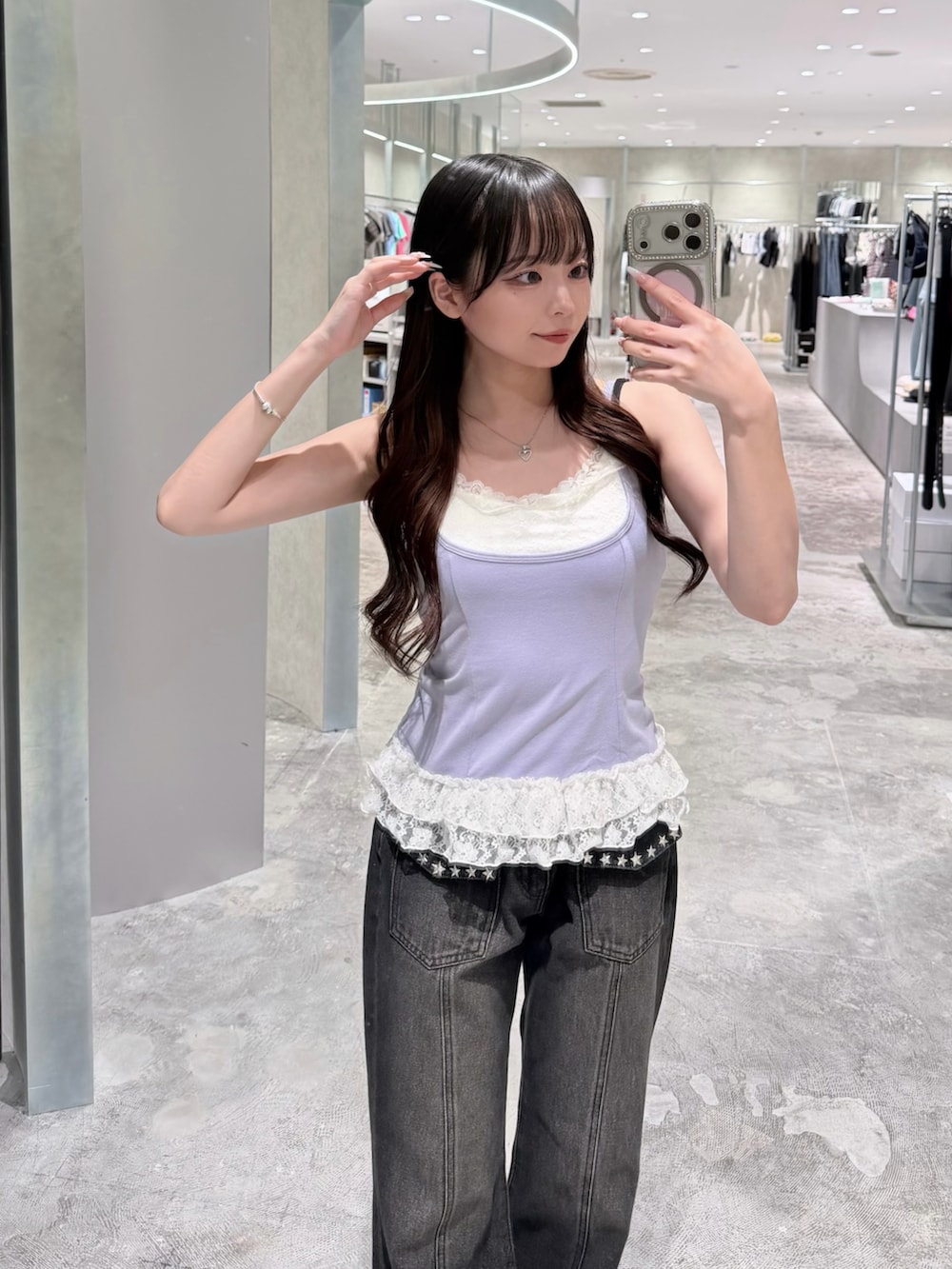 パープル系のタンクトップ、ブラック系のデニムパンツ、ブラック系のパンプスを着用したレディースの夏コーディネートの2枚目の写真