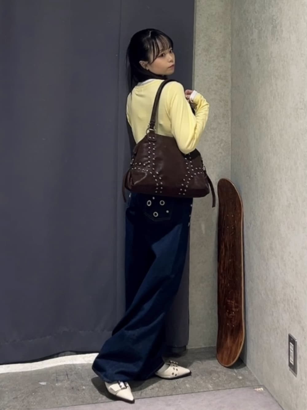 イエロー系のTシャツ/カットソー、ブルー系のデニムパンツ、ブラウン系のショルダーバッグを着用したレディースの春コーディネートの3枚目の写真