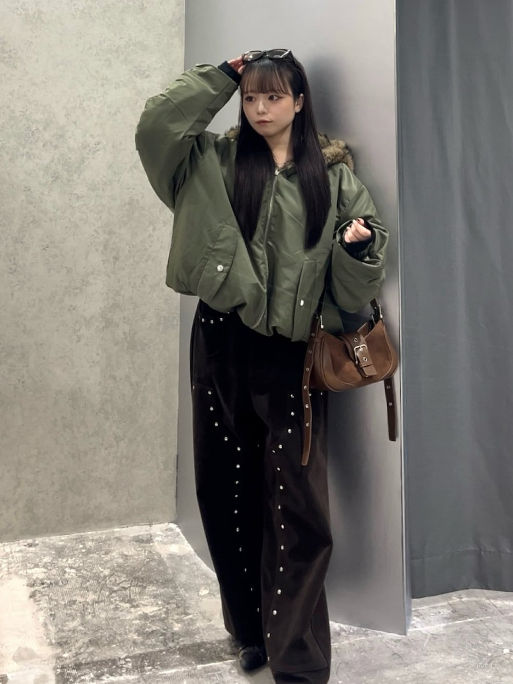 グリーン系のブルゾン、ブラウン系のパンツ、ブラウン系のショルダーバッグを着用したレディースの秋コーディネートの2枚目の写真