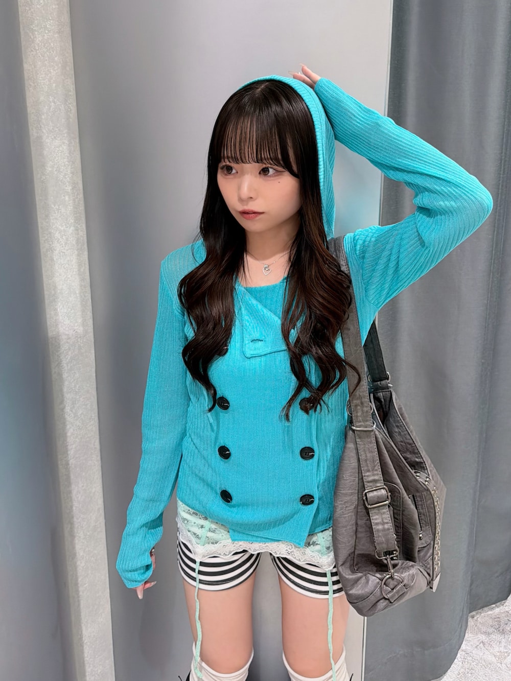 ブルー系のパーカー、グリーン系のキャミソール、ホワイト系のその他パンツを着用したレディースの秋コーディネートの5枚目の写真