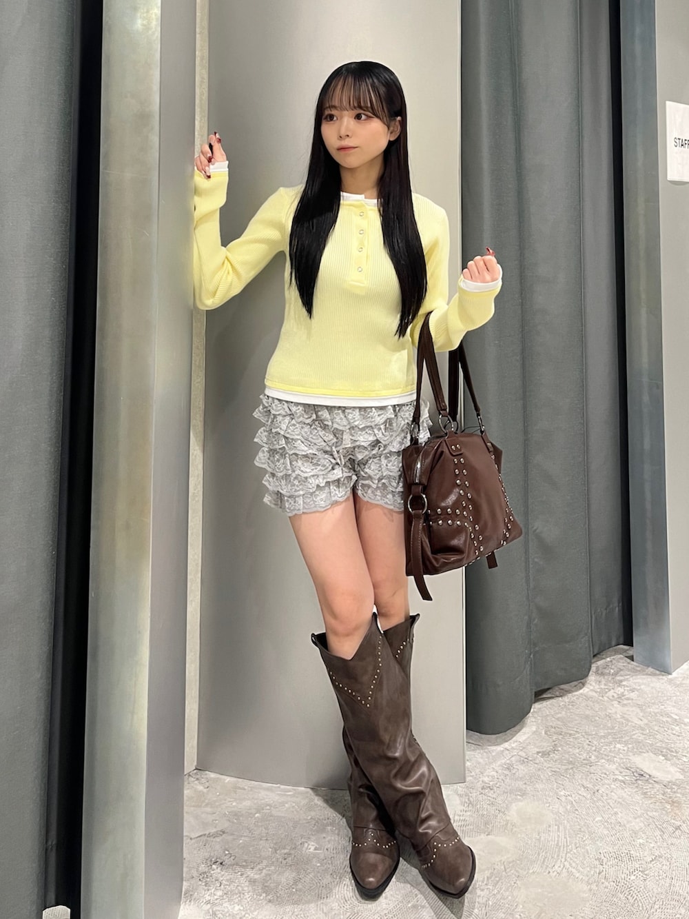 イエロー系のニット/セーター、グレー系のその他パンツ、ブラウン系のブーツを着用したレディースの冬コーディネートの2枚目の写真