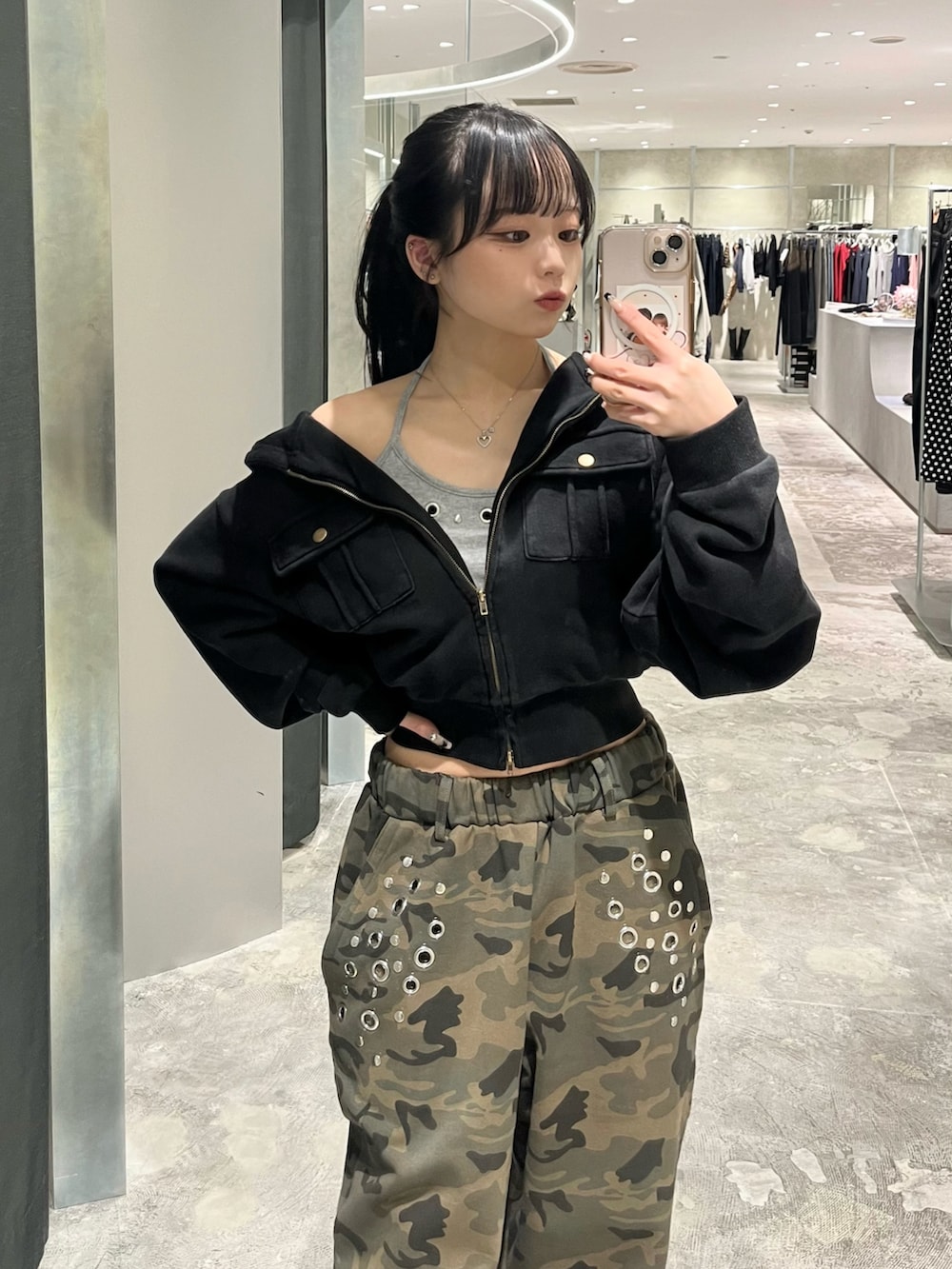 グレー系のパーカー、グレー系のキャミソール、グリーン系のスウェットパンツを着用したレディースの春コーディネートの2枚目の写真