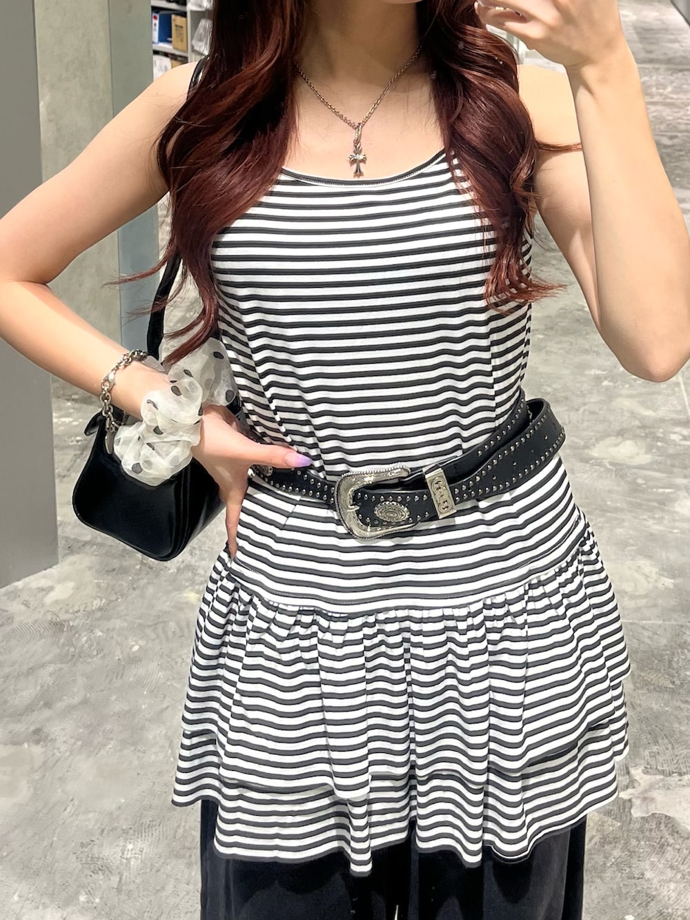 ホワイト系のチュニック、ブラック系のショルダーバッグ、ブラック系のスウェットパンツを着用したレディースの夏コーディネートの2枚目の写真