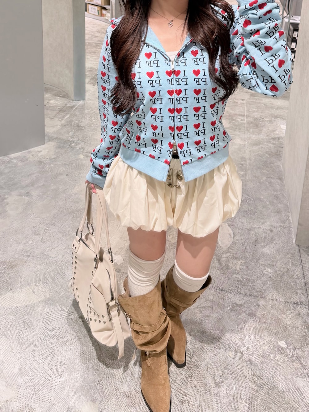 ブルー系のパーカー、ホワイト系のその他パンツ、ベージュ系のブーツを着用したレディースの秋コーディネートの2枚目の写真