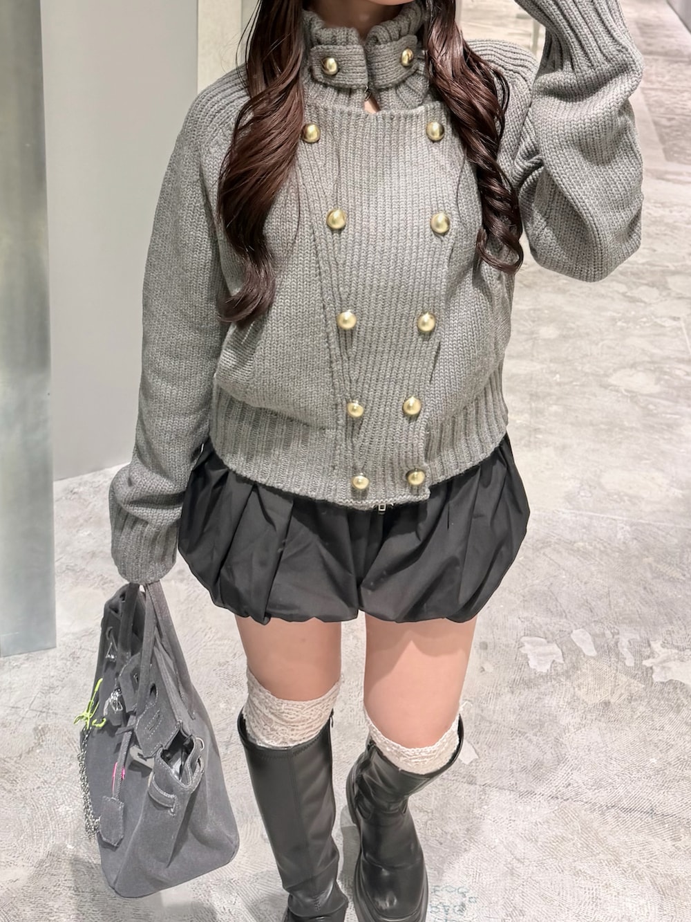 グレー系のニット/セーター、ブラック系のその他パンツ、グレー系のボストンバッグを着用したレディースの秋コーディネートの2枚目の写真