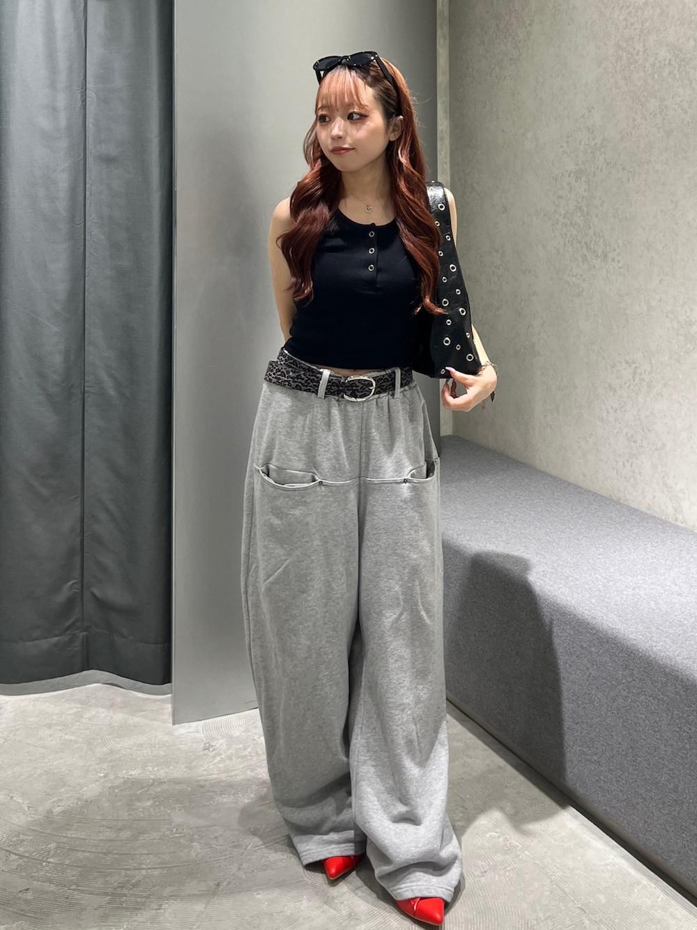 ブラック系のタンクトップ、グレー系のスウェットパンツ、ブラック系のショルダーバッグを着用したレディースの夏コーディネートの2枚目の写真