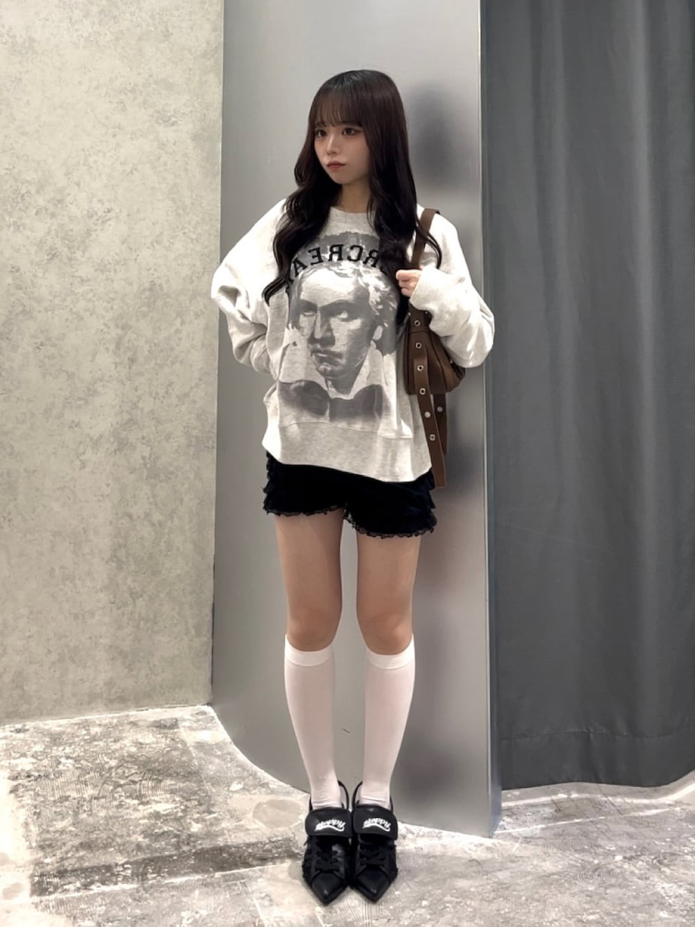 ホワイト系のスウェット、ブラック系のその他パンツ、ブラウン系のショルダーバッグを着用したレディースの秋コーディネートの3枚目の写真