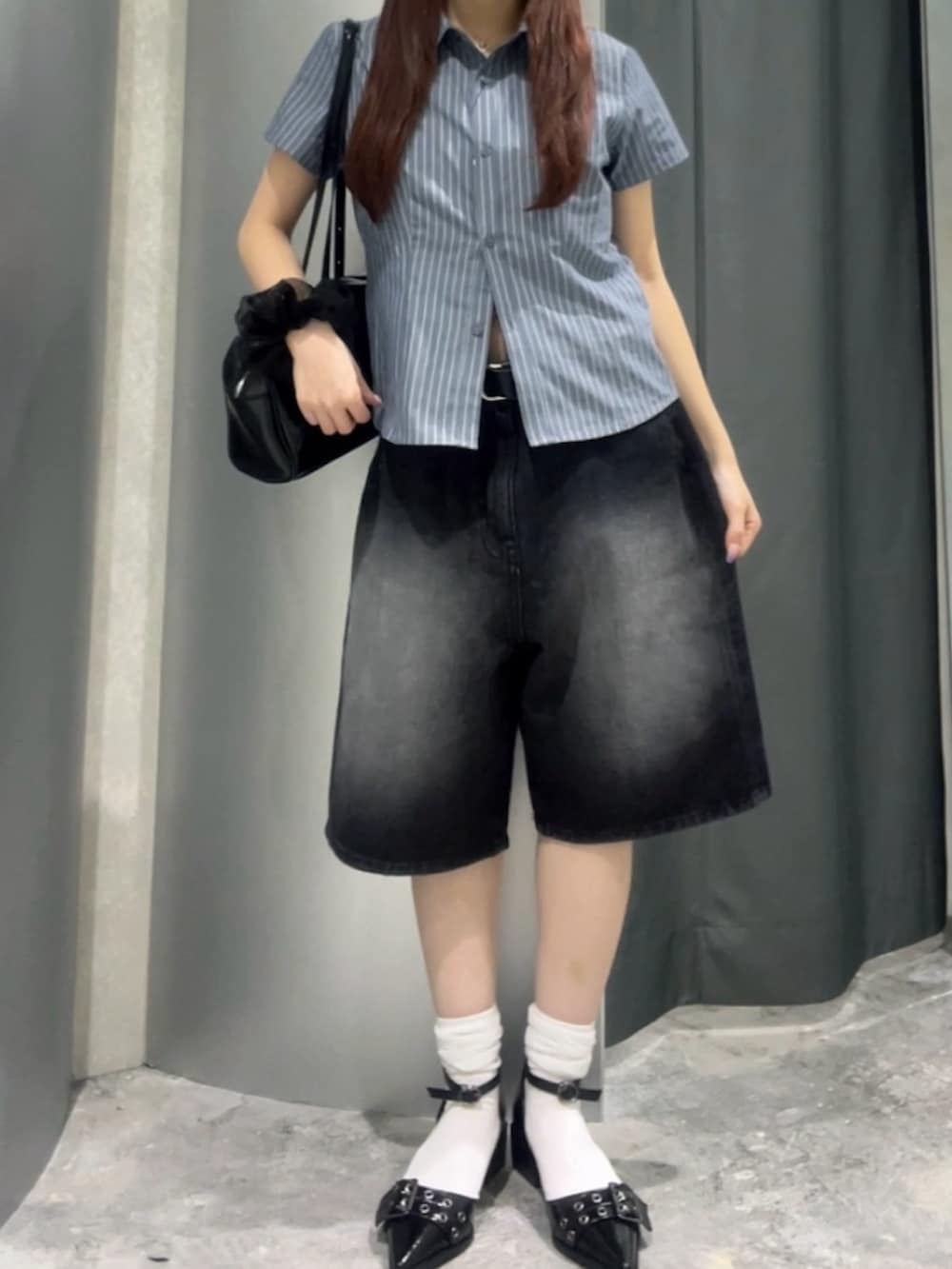 ブラック系のショルダーバッグ、ブルー系のシャツ/ブラウス、ブラック系のデニムパンツを着用したレディースの夏コーディネートの3枚目の写真