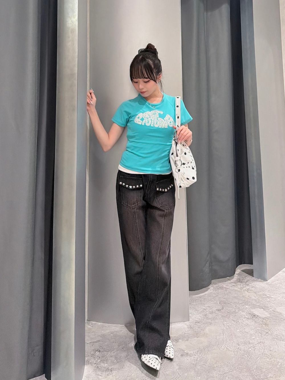 グリーン系のTシャツ/カットソー、ブラック系のデニムパンツ、ホワイト系のパンプスを着用したレディースの夏コーディネートの2枚目の写真
