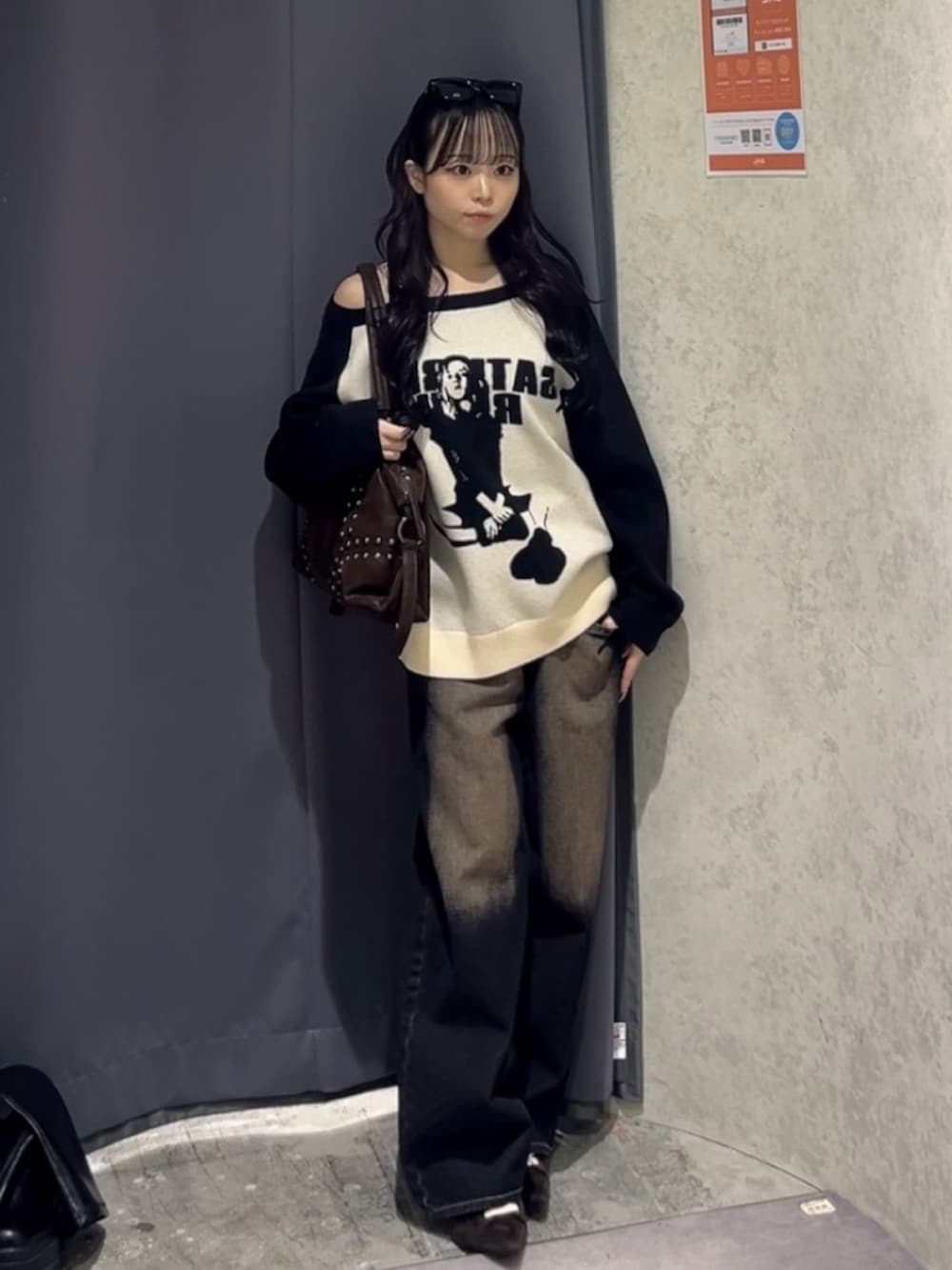 ブラック系のニット/セーター、ブルー系のデニムパンツ、ブラウン系のショルダーバッグを着用したレディースの冬コーディネートの2枚目の写真