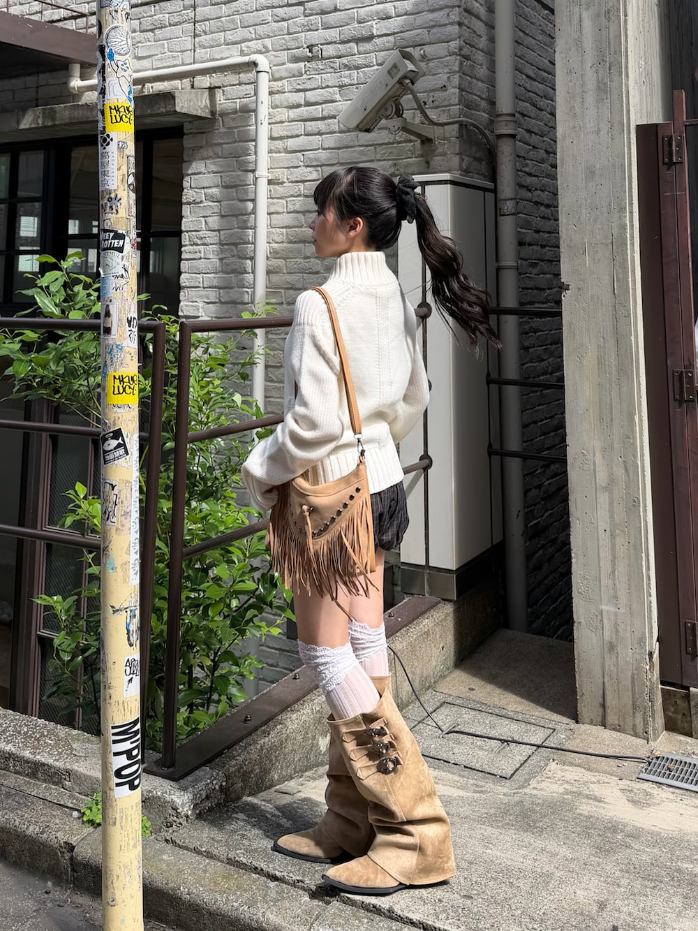 ホワイト系のニット/セーター、ブラウン系のパンツ、ベージュ系のブーツを着用したレディースの夏コーディネートの2枚目の写真