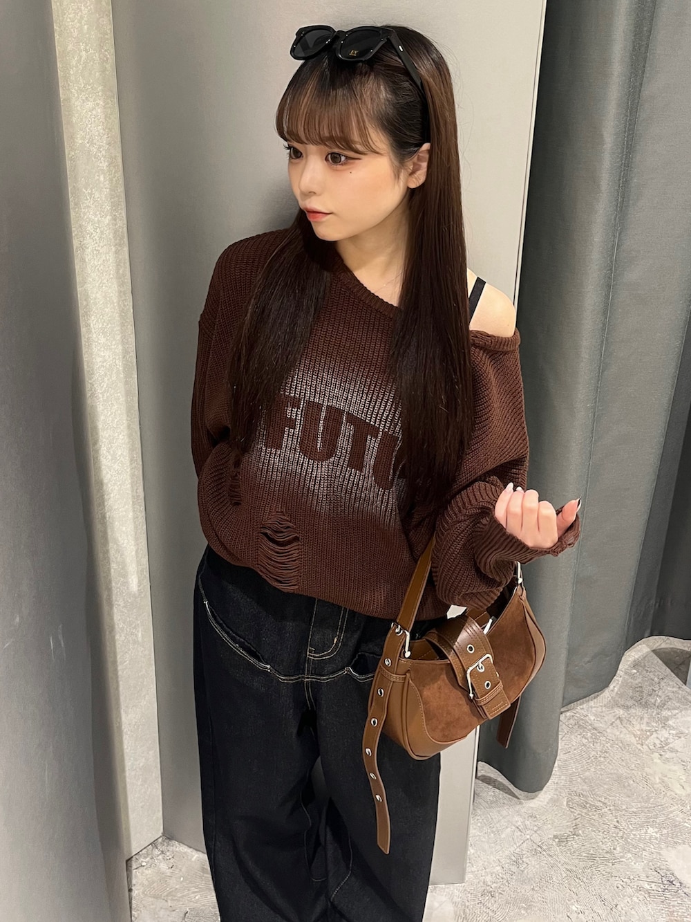 ブラウン系のニット/セーター、ブルー系のデニムパンツ、ブラウン系のショルダーバッグを着用したレディースの秋コーディネートの2枚目の写真
