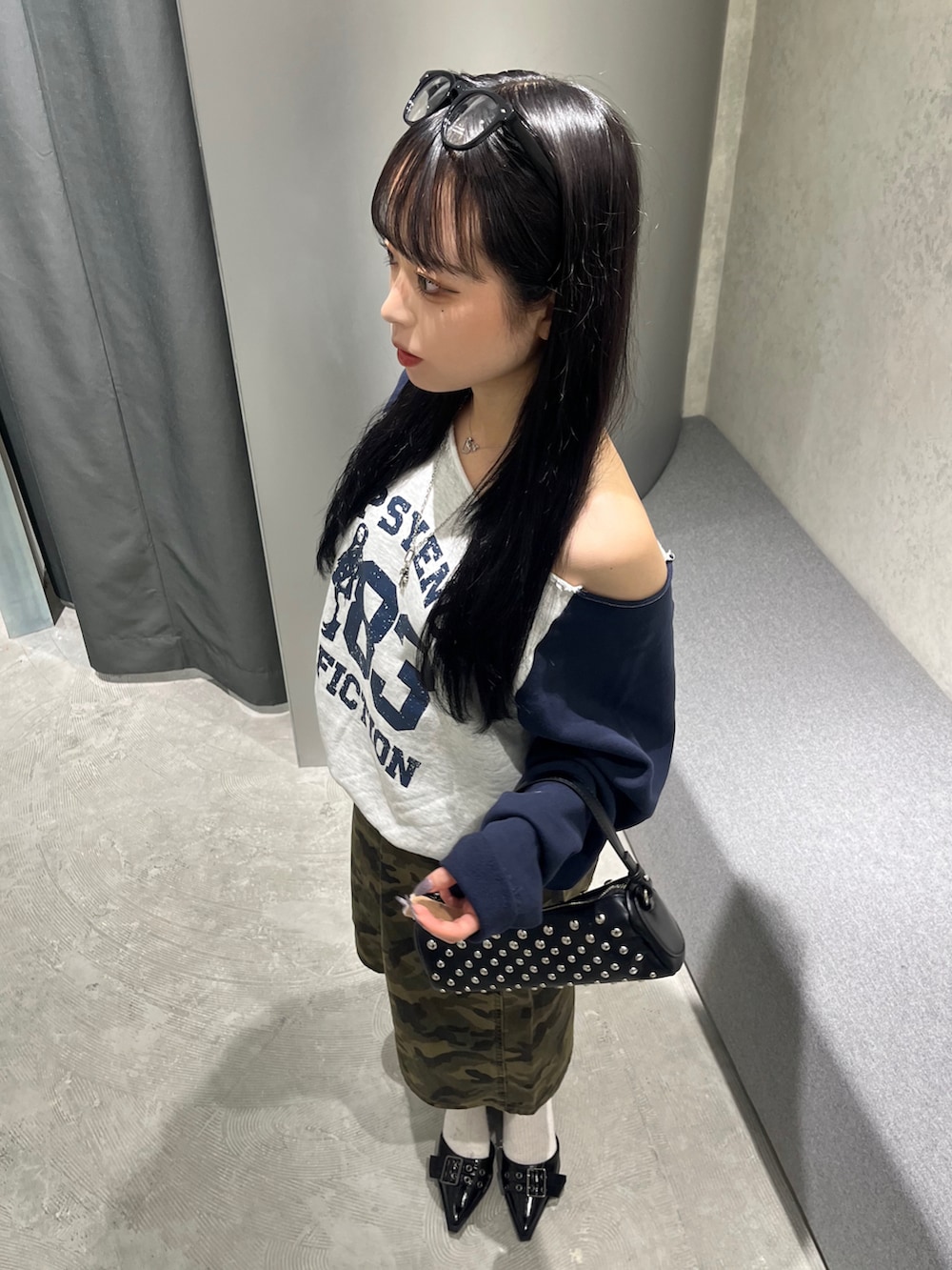 グレー系のスウェット、ブラック系のショルダーバッグ、グリーン系のチノパンツを着用したレディースの夏コーディネートの2枚目の写真