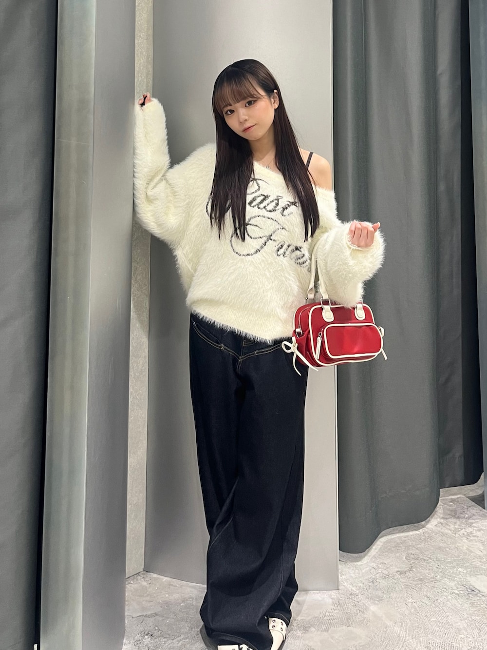 ホワイト系のニット/セーター、ブルー系のデニムパンツ、ホワイト系のパンプスを着用したレディースの秋コーディネートの2枚目の写真