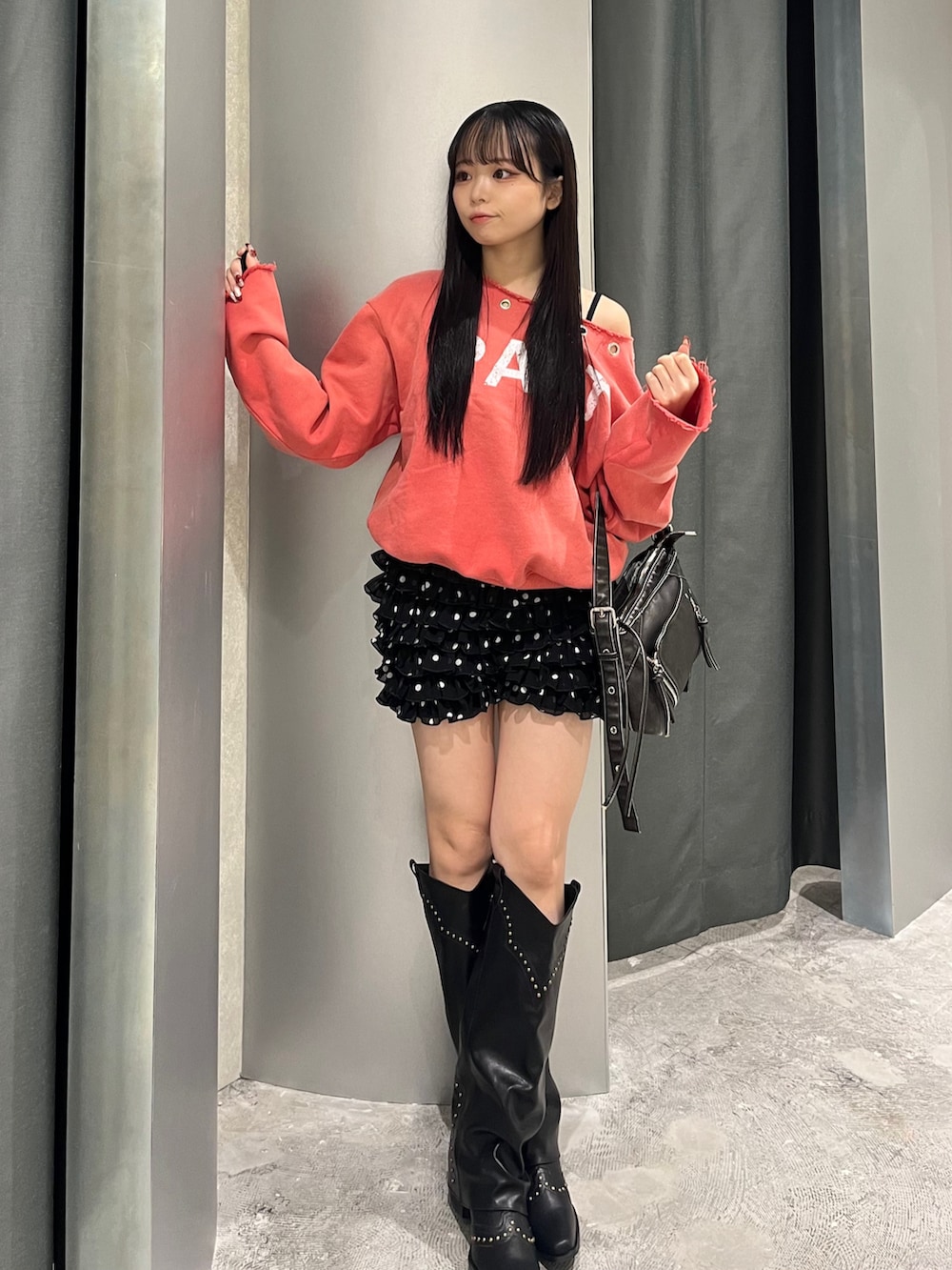 オレンジ系のスウェット、ブラック系のその他パンツ、ブラック系のブーツを着用したレディースの冬コーディネートの2枚目の写真