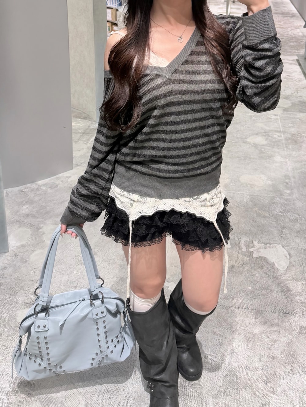 グレー系のニット/セーター、ホワイト系のキャミソール、ブラック系のその他パンツを着用したレディースの秋コーディネートの3枚目の写真