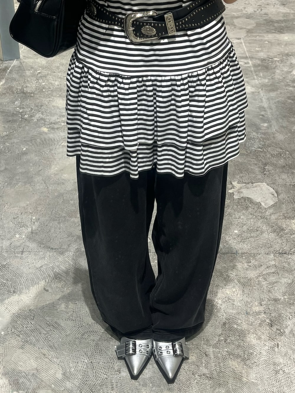 ホワイト系のチュニック、ブラック系のショルダーバッグ、ブラック系のスウェットパンツを着用したレディースの夏コーディネートの3枚目の写真