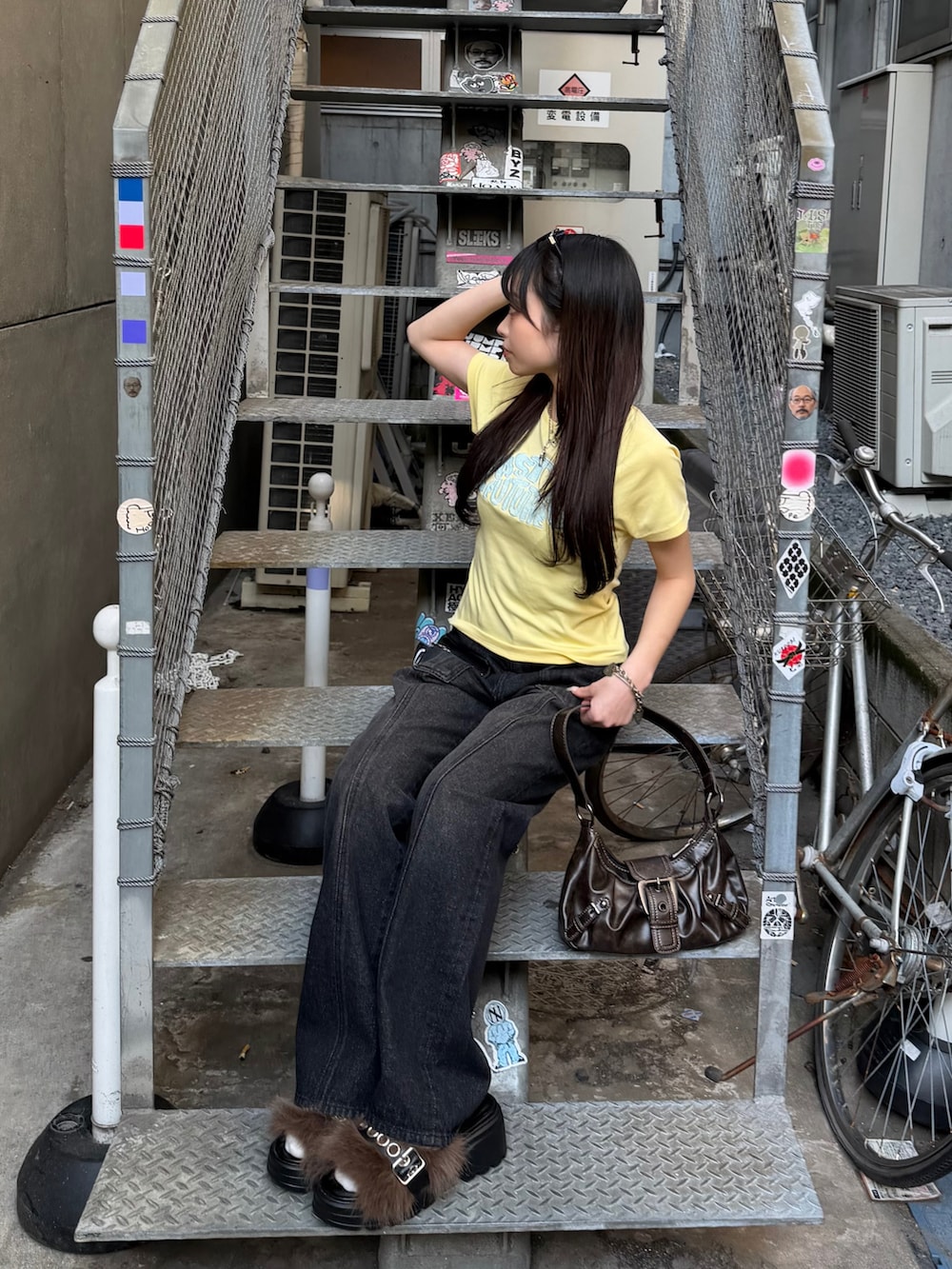 イエロー系のTシャツ/カットソー、ブラック系のデニムパンツ、ブラック系のサンダルを着用したレディースの春コーディネートの2枚目の写真
