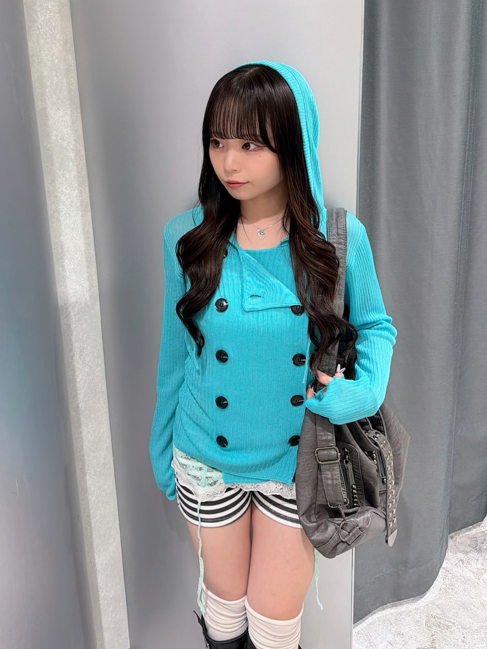ブルー系のパーカー、グリーン系のキャミソール、ホワイト系のその他パンツを着用したレディースの秋コーディネートの4枚目の写真
