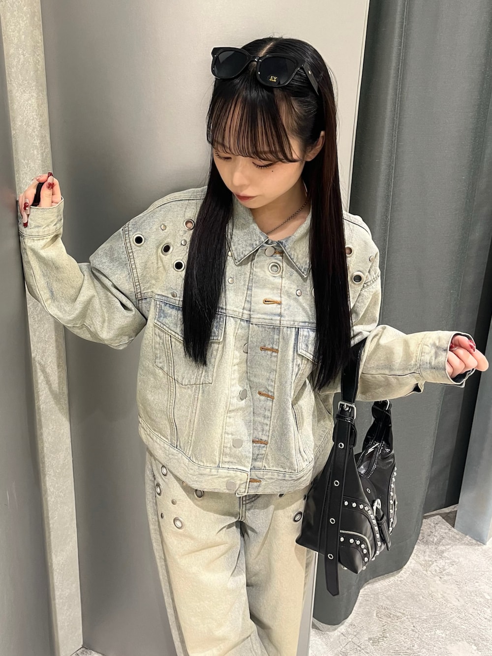 ブルー系のデニムジャケット、ブルー系のデニムパンツ、ブラック系のショルダーバッグを着用したレディースの冬コーディネートの3枚目の写真