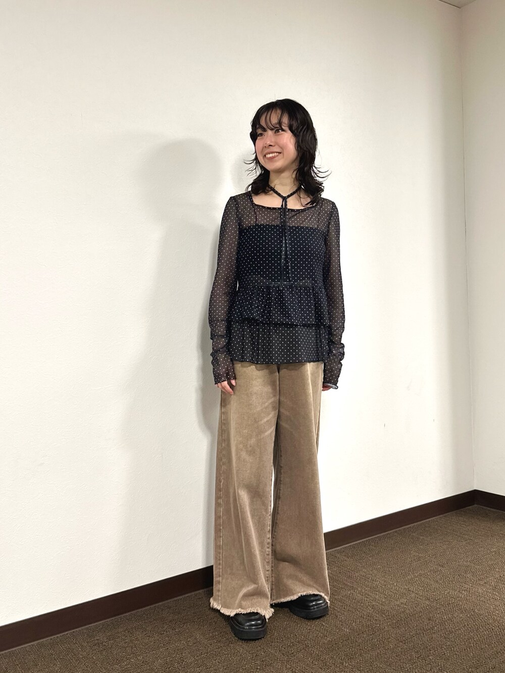 ブラック系のTシャツ/カットソー、ブラック系のキャミソール、ブラウン系のデニムパンツを着用したレディースの秋コーディネートの2枚目の写真