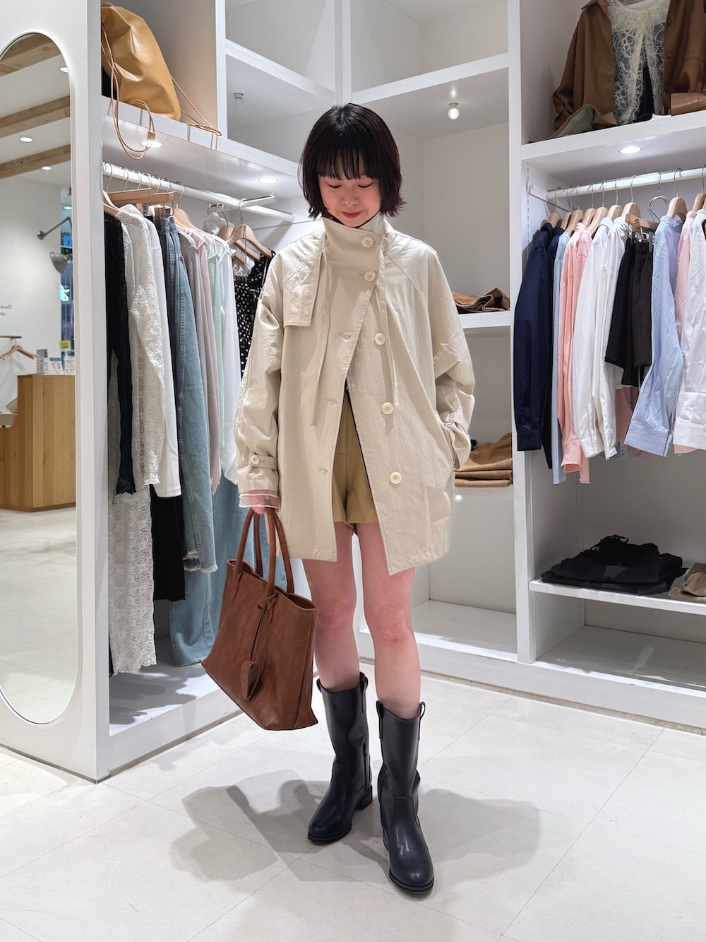 ホワイト系のトレンチコート、ホワイト系のTシャツ/カットソー、ブラック系のカーディガン/ボレロを着用したレディースの春コーディネートの3枚目の写真