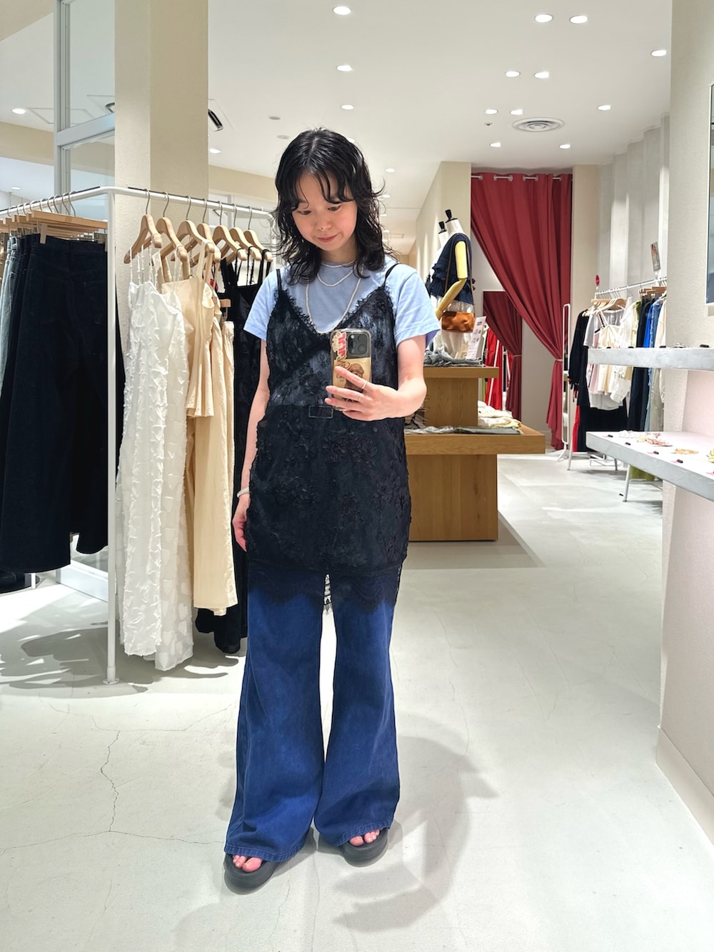 ブルー系のTシャツ/カットソー、ブラック系のシャツ/ブラウス、ブルー系のデニムパンツを着用したレディースの秋コーディネートの2枚目の写真