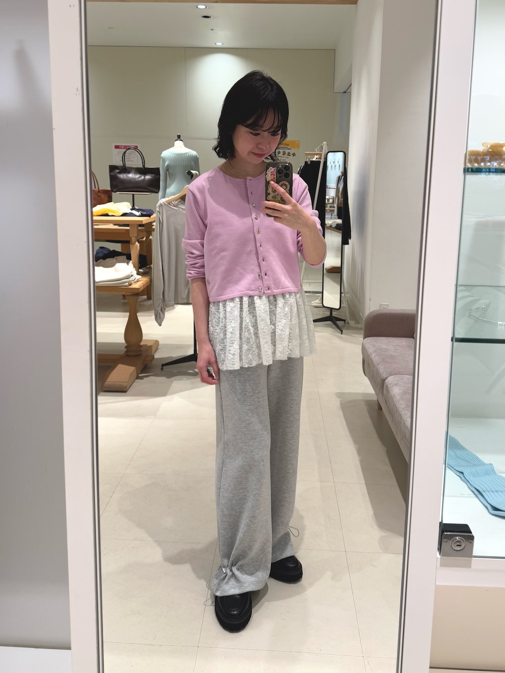 ピンク系のカーディガン/ボレロ、ホワイト系のキャミソール、グレー系のスウェットパンツを着用したレディースの春コーディネートの2枚目の写真