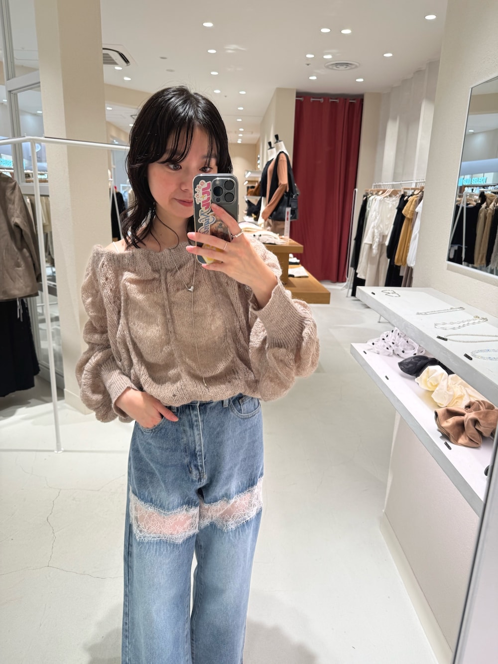 ブルー系のデニムパンツ、ブラウン系のパンプス、ホワイト系のキャミソールを着用したレディースの秋コーディネートの2枚目の写真