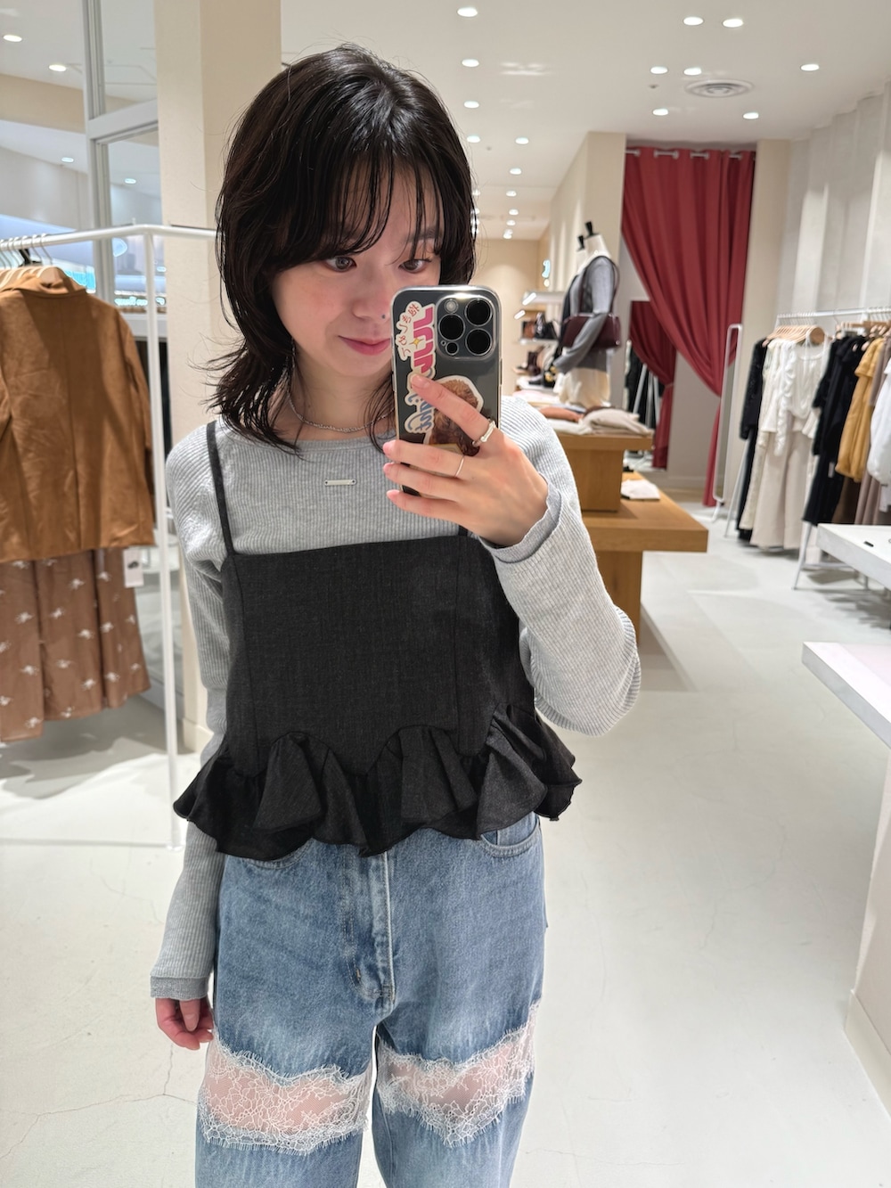 グレー系のニット/セーター、グレー系のシャツ/ブラウス、ブルー系のデニムパンツを着用したレディースの秋コーディネートの2枚目の写真