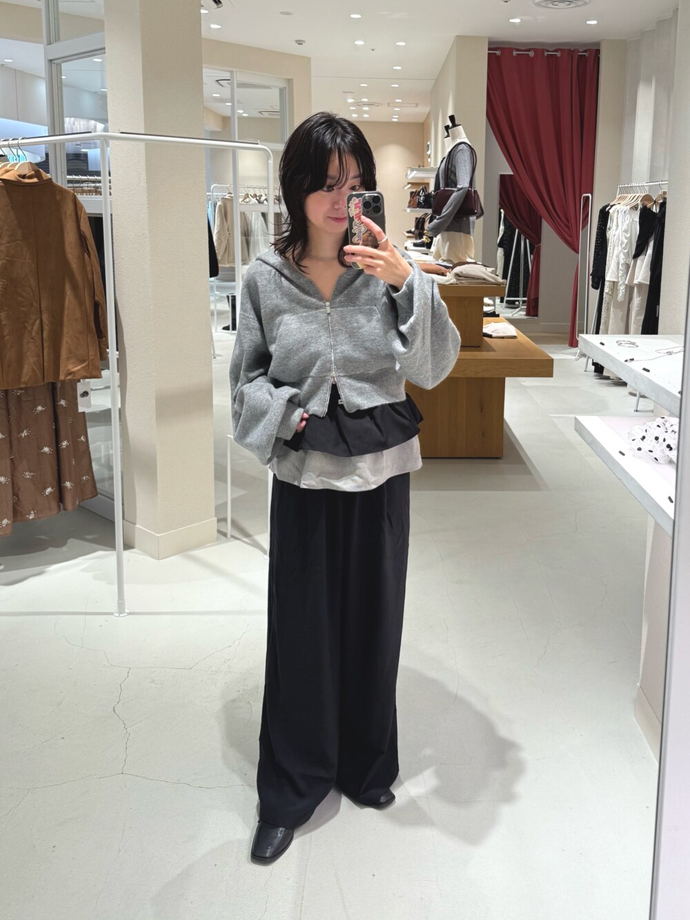 グレー系のパーカー、ブラック系のその他パンツ、シルバー系のネックレスを着用したレディースの秋コーディネートの2枚目の写真