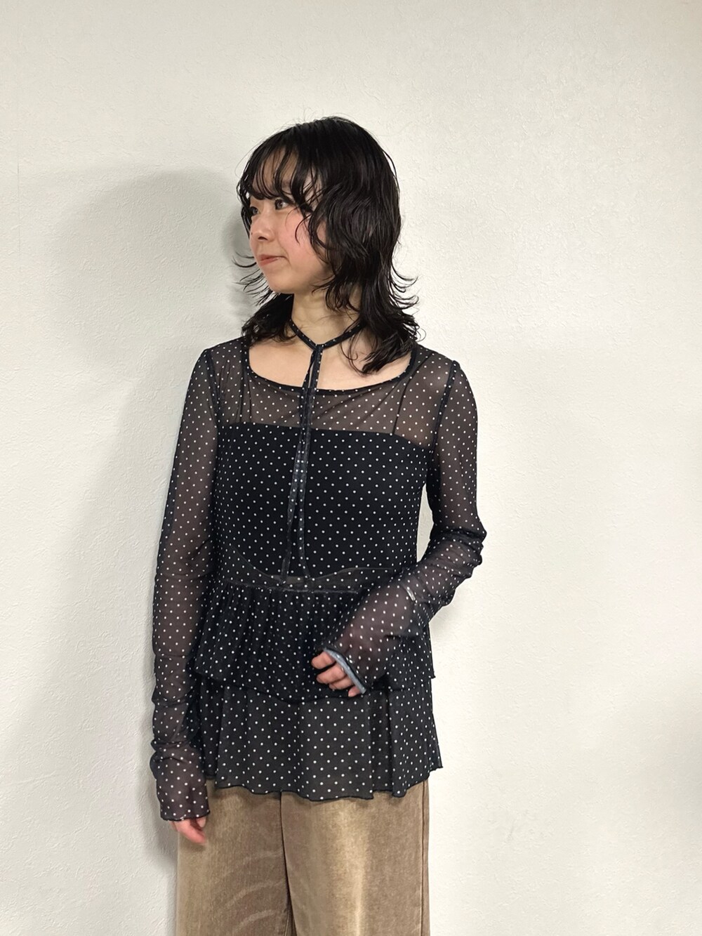 ブラック系のTシャツ/カットソー、ブラック系のキャミソール、ブラウン系のデニムパンツを着用したレディースの秋コーディネートの3枚目の写真