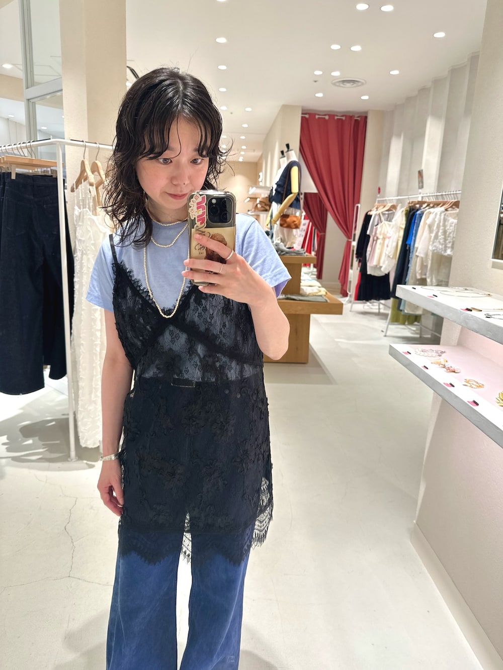 ブルー系のTシャツ/カットソー、ブラック系のシャツ/ブラウス、ブルー系のデニムパンツを着用したレディースの秋コーディネートの3枚目の写真