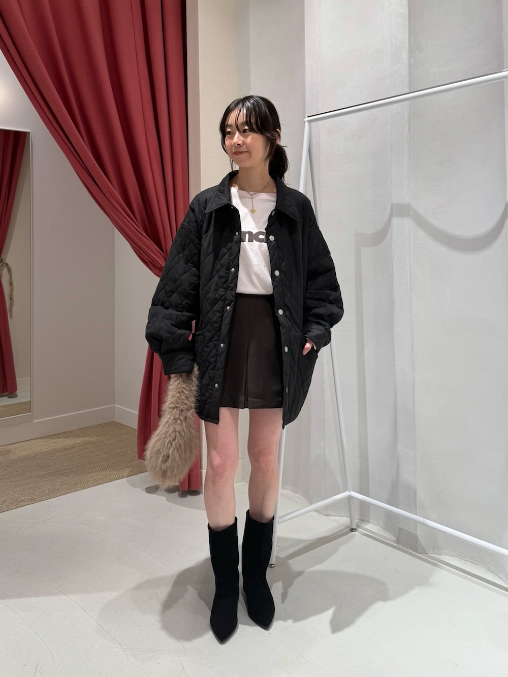 ピンク系のTシャツ/カットソー、ブラック系のその他アウター、ブラウン系のスカートを着用したレディースの秋コーディネートの2枚目の写真