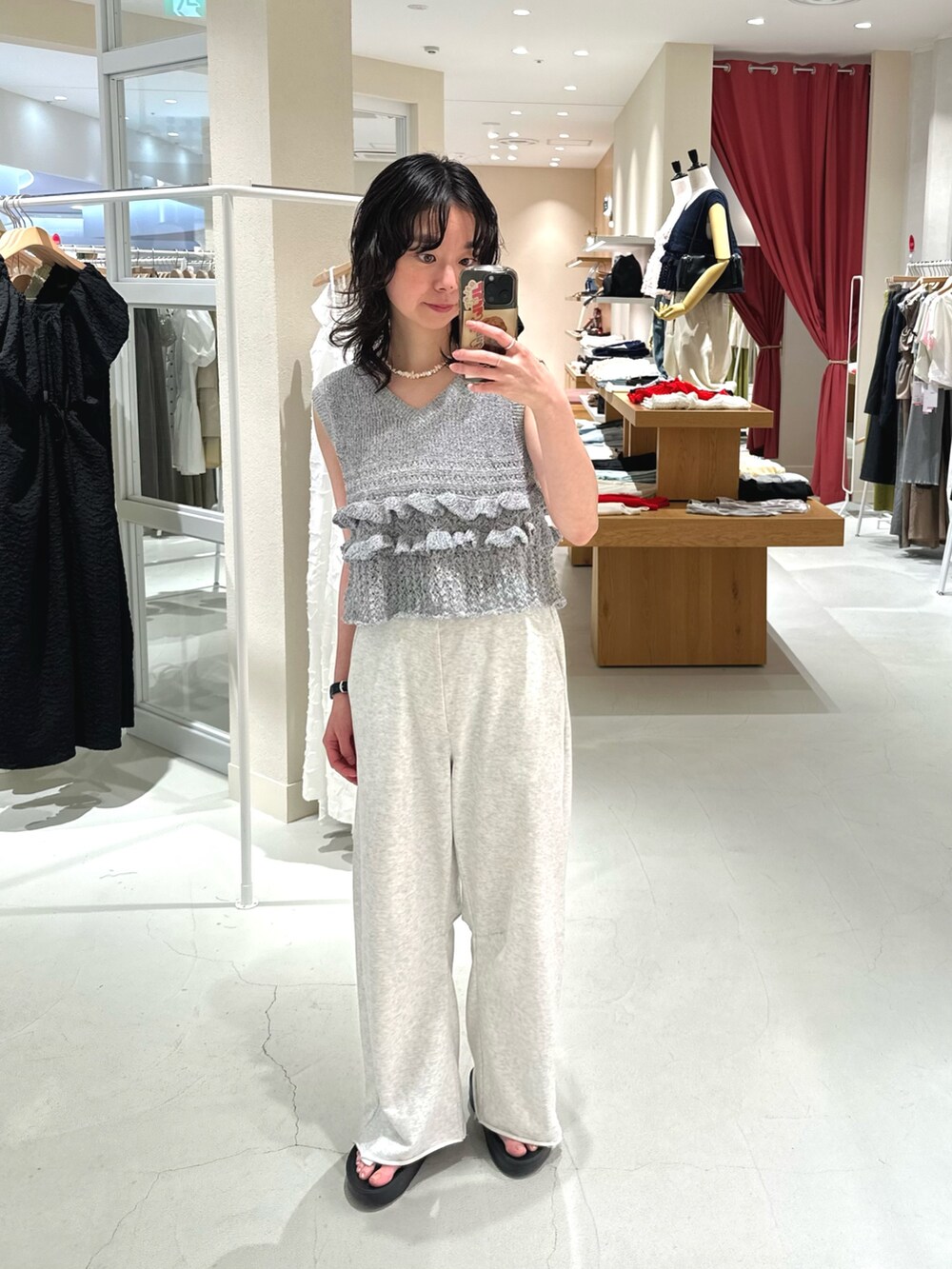 グレー系のベスト、グレー系のスウェットパンツを着用したレディースの秋コーディネートの2枚目の写真