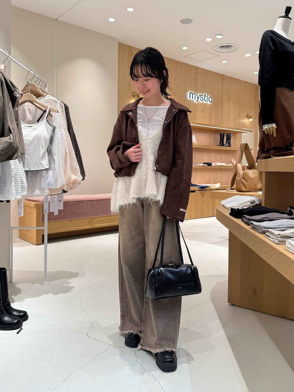 ブラウン系のブルゾン、ホワイト系のベスト、ホワイト系のTシャツ/カットソーを着用したレディースの秋コーディネートの3枚目の写真