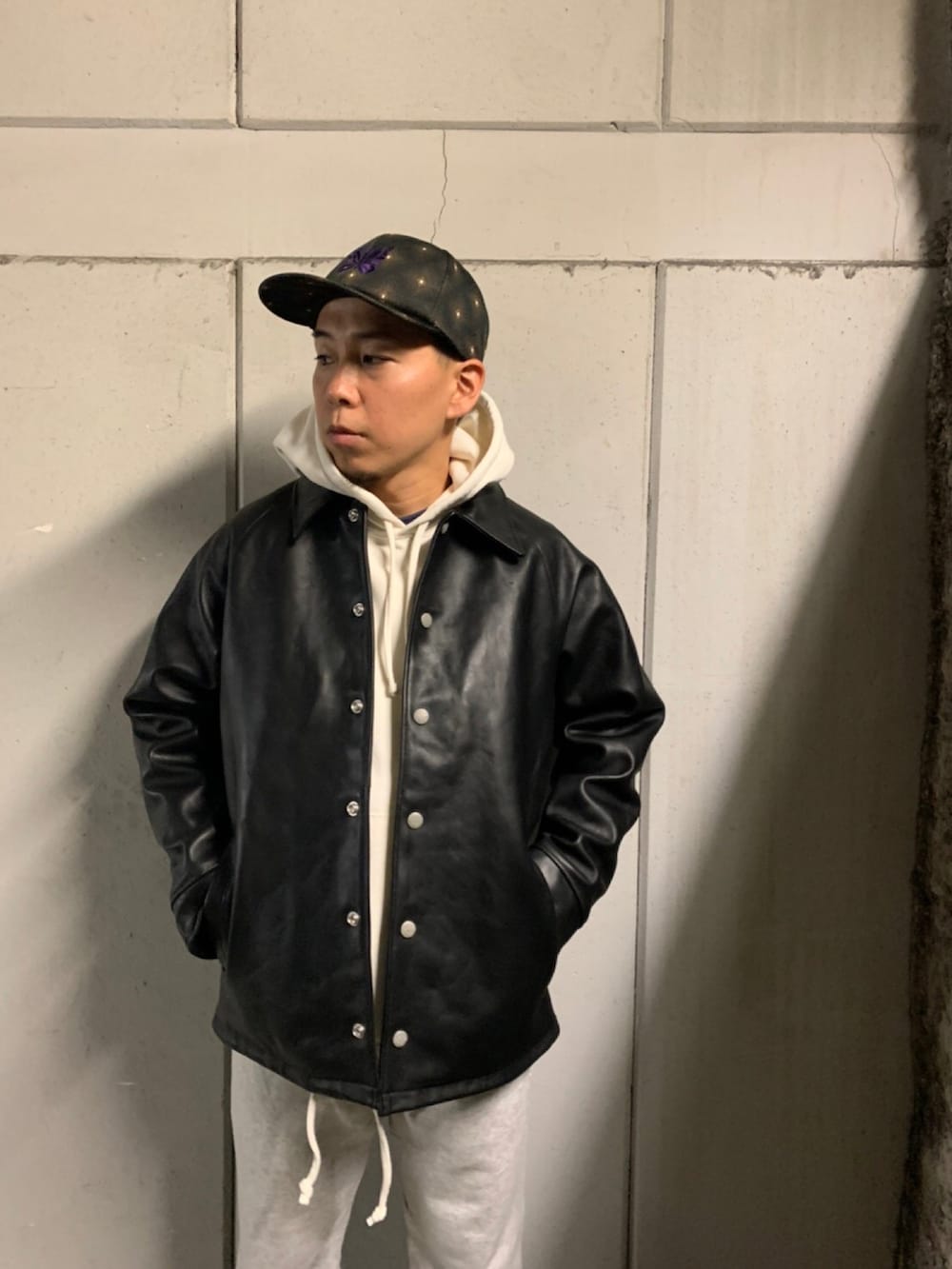 グレー系のスウェットパンツ、ブラック系のその他シューズ、ホワイト系のパーカーを着用したメンズの秋コーディネートの2枚目の写真