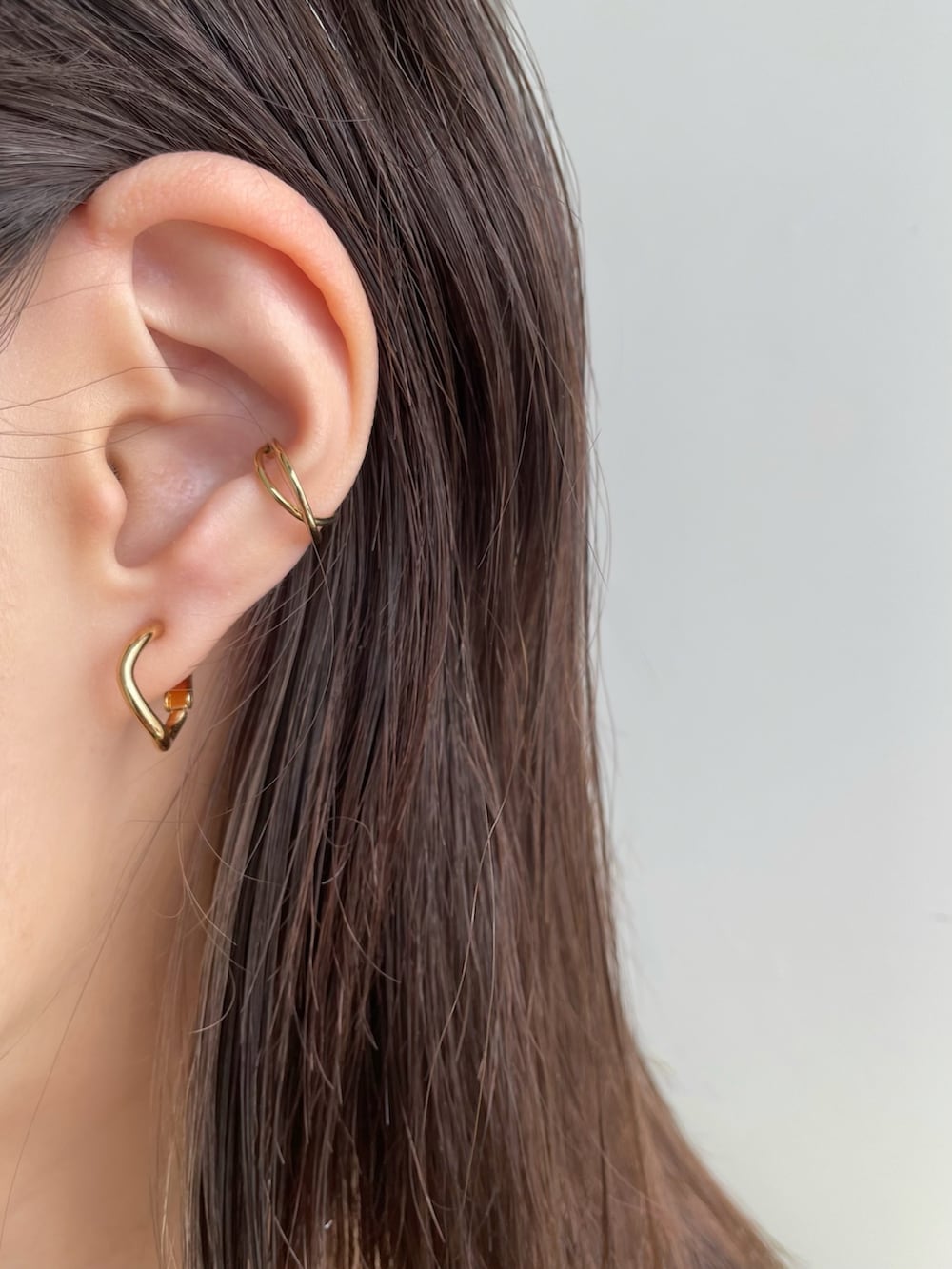 ゴールド系のイヤリング、ゴールド系のイヤーカフを着用したレディースの春コーディネートの2枚目の写真