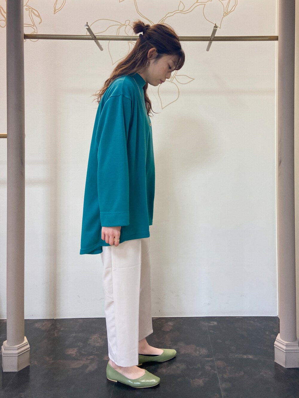 その他のノーカラーコート、グリーン系のTシャツ/カットソー、ホワイト系のスラックスを着用したレディースの春コーディネートの5枚目の写真