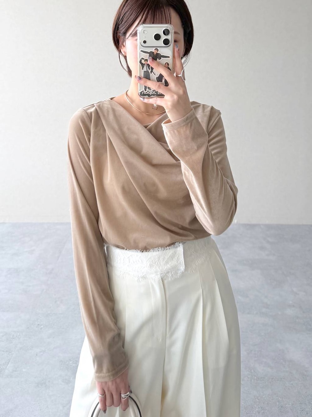 ベージュ系のトレンチコート、ベージュ系のTシャツ/カットソー、ホワイト系のスラックスを着用したレディースの秋コーディネートの8枚目の写真