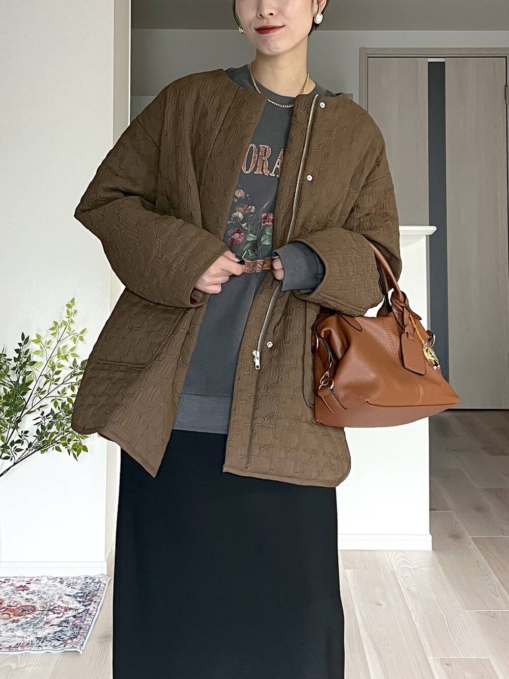 ブラウン系のボストンバッグ、ブラック系のスカート、ベージュ系のネックレスを着用したレディースの秋コーディネートの4枚目の写真