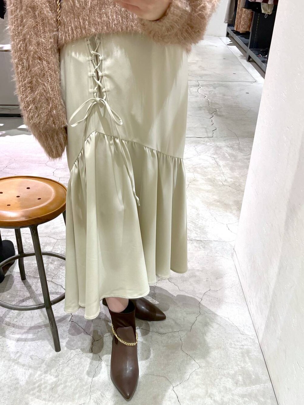 ホワイト系のショルダーバッグ、ブラウン系のブーツ、ブラウン系のニット/セーターを着用したレディースの冬コーディネートの5枚目の写真