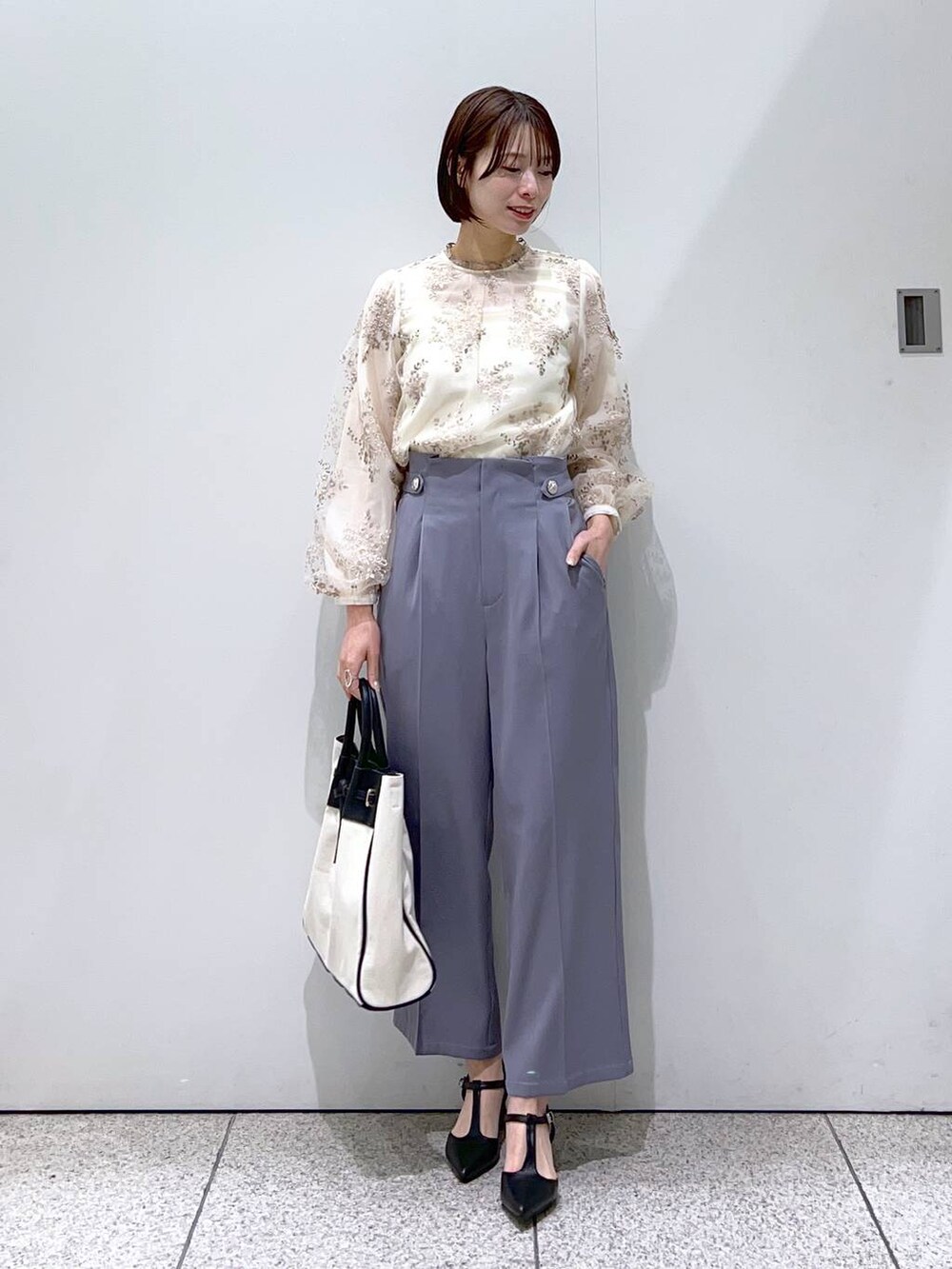 ブラック系のトートバッグ、ホワイト系のシャツ/ブラウス、ブラック系のパンプスを着用したレディースの冬コーディネートの4枚目の写真