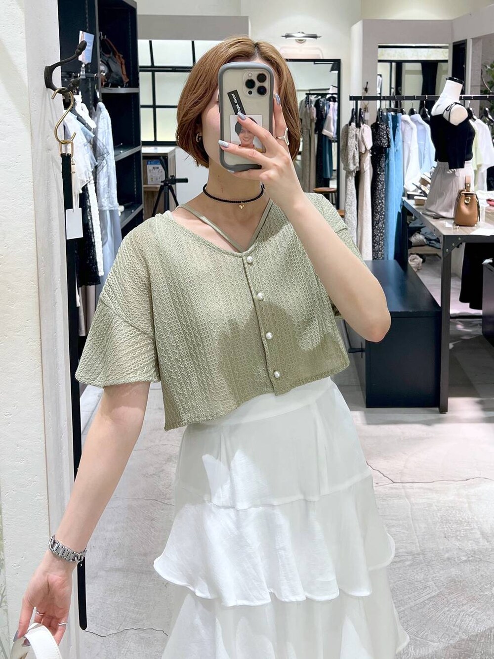 グリーン系のカーディガン/ボレロ、ベージュ系のサンダル、ホワイト系のショルダーバッグを着用したレディースの夏コーディネートの5枚目の写真