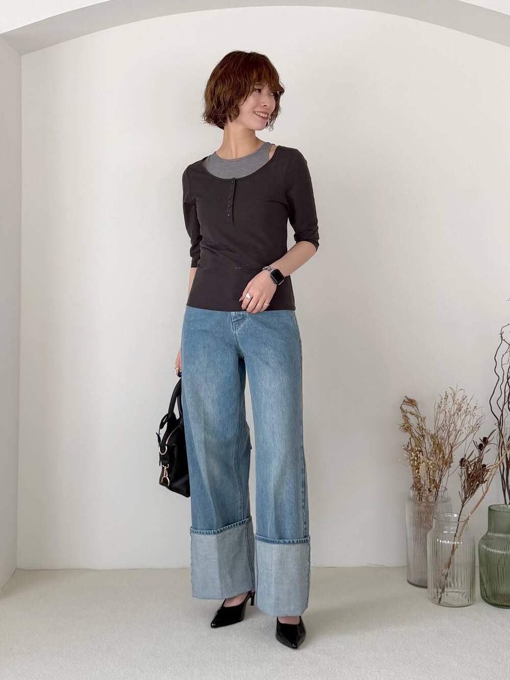 ブラック系のボストンバッグ、ブラック系のサンダル、ブルー系のデニムパンツを着用したレディースの春コーディネートの5枚目の写真