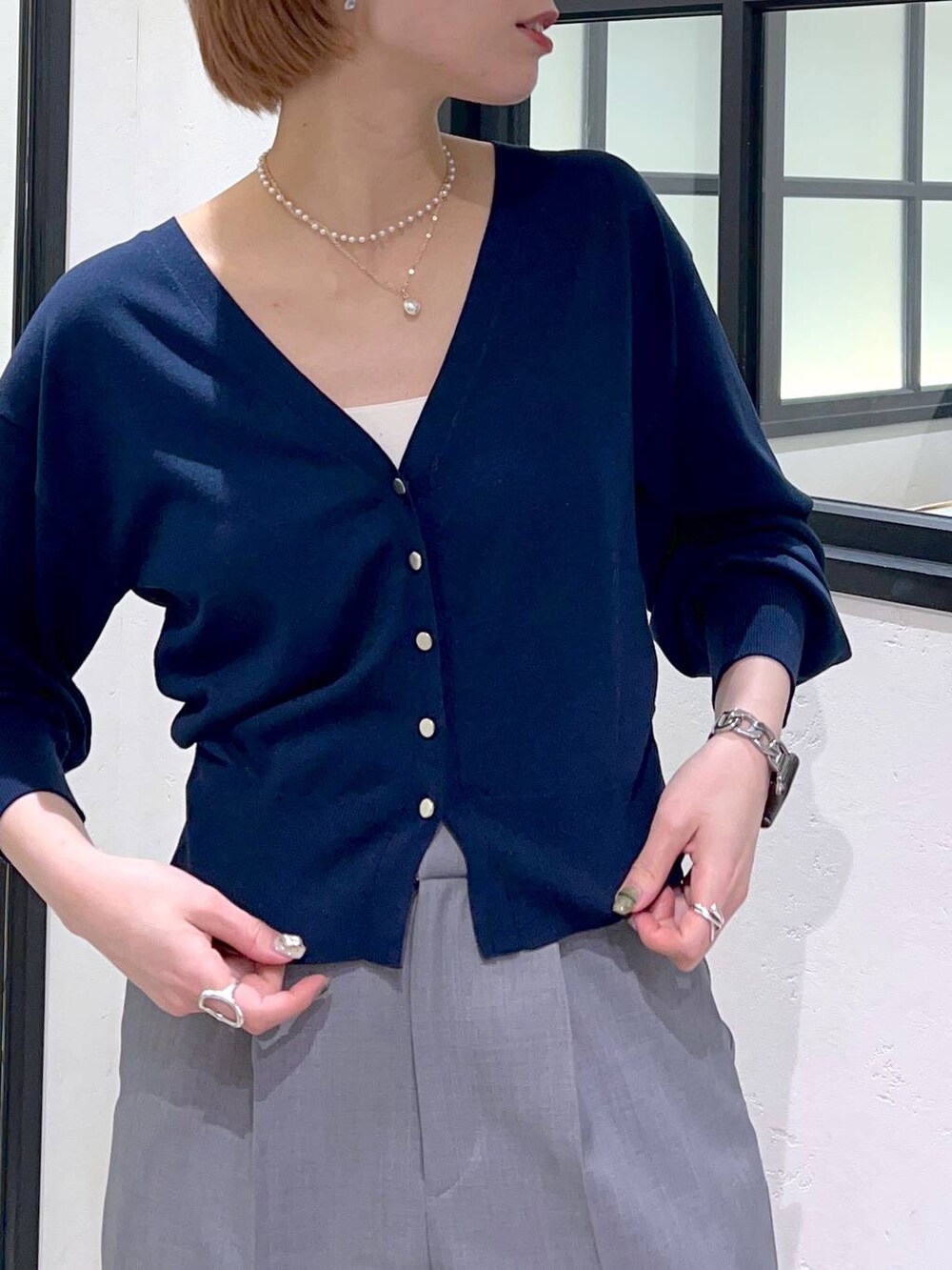 ブルー系のカーディガン/ボレロ、ブラック系のパンプス、ホワイト系のキャミソールを着用したレディースの春コーディネートの3枚目の写真